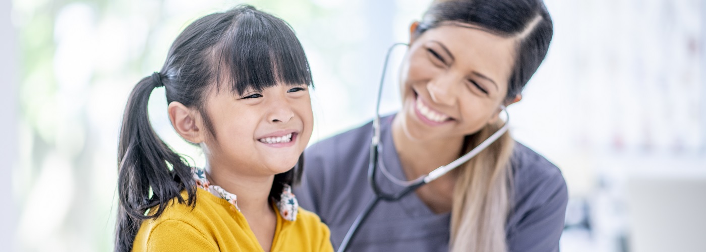 A smiling girl during a check-up with a paediatrician